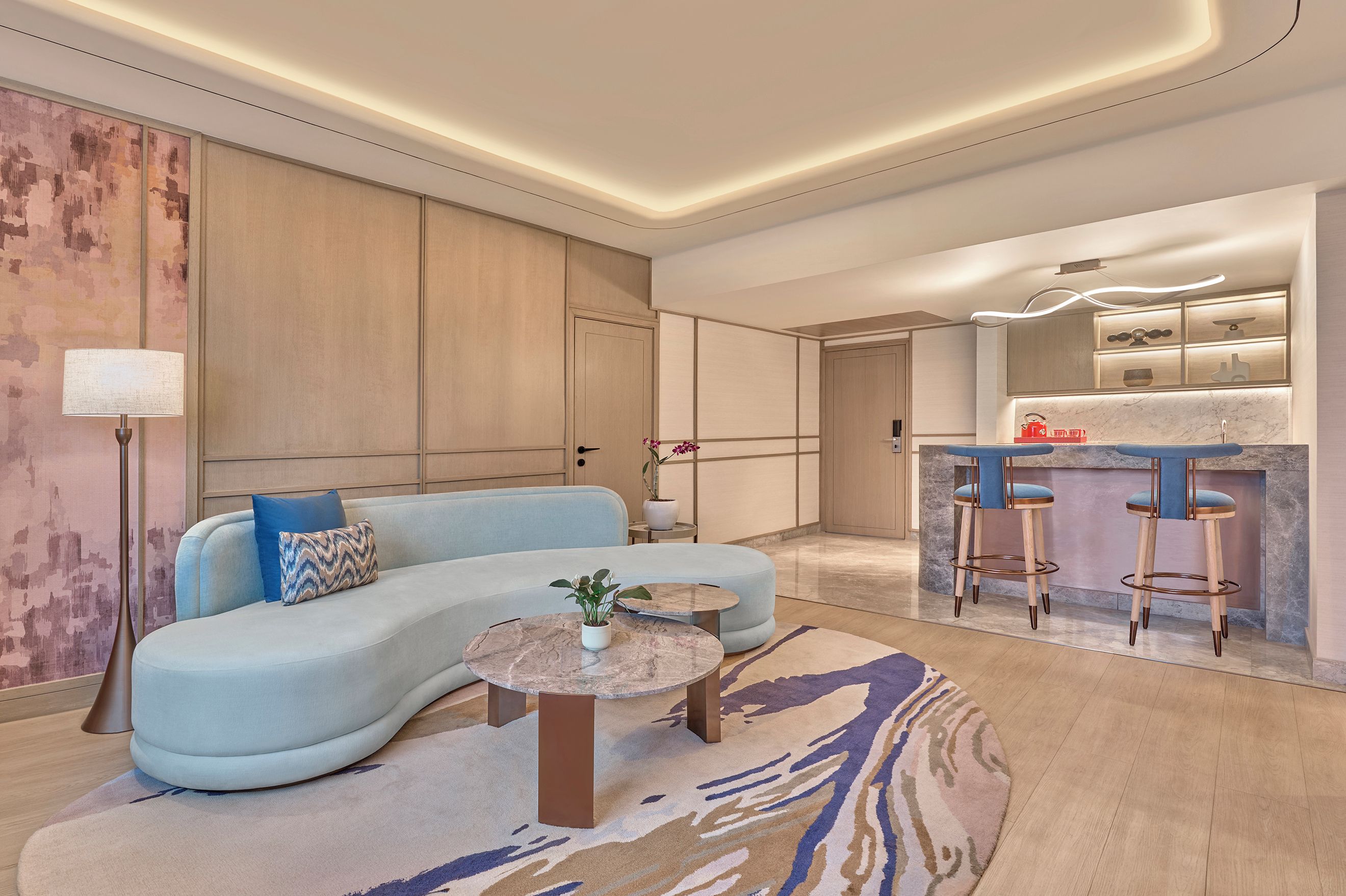 A modern living room with a curved sofa, a round coffee table, and a small side table.