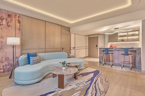 A modern living room with a curved sofa, a round coffee table, and a small side table. - Athiva Pulse Navi Mumbai, Autograph Collection (Navi Mumbai)