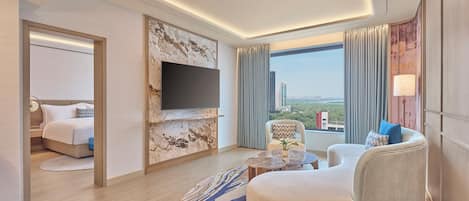 Habitación de hotel moderna con cama, zona de estar, televisor de pantalla plana y vistas a la ciudad.