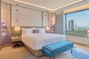A modern hotel room with a large bed, a view of the city, and a cityscape visible through the window. - Athiva Pulse Navi Mumbai, Autograph Collection (Navi Mumbai)