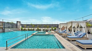 A rooftop pool with multiple lanes, sun loungers, and a pergola with a canopy. - Athiva Pulse Navi Mumbai, Autograph Collection (Navi Mumbai)