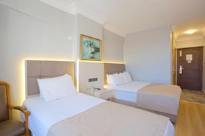 A hotel room with two beds, a nightstand, a chair, and a door. - Palette Grand Ant Hotel Istanbul (Istanbul)