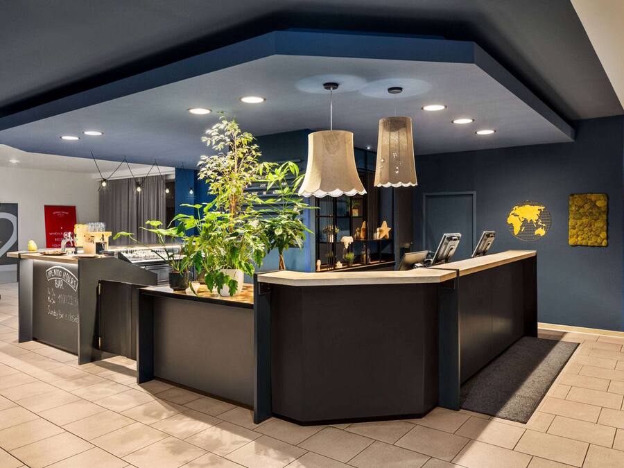 A modern reception area with a dark blue accent wall, a reception desk, and a potted plant.