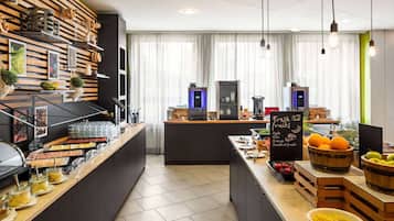 A breakfast bar with a variety of food items and a chalkboard sign advertising fresh fruits.