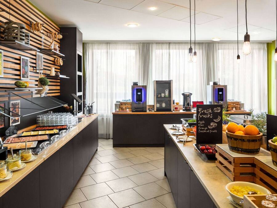 A breakfast bar with a variety of food items and a chalkboard sign advertising fresh fruits.