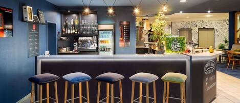 Zona de bar con taburetes, una barra y estantes con botellas y vasos.