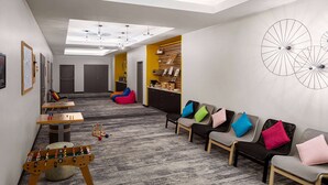 A modern waiting area with seating, a foosball table, and a reception desk. - Vienna House Easy by Wyndham Bratislava (Bratislava)