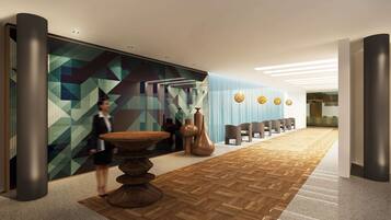 Een moderne lobby met een wand met een geometrisch patroon, een houten vloer en een receptiegedeelte met stoelen en een bureau.