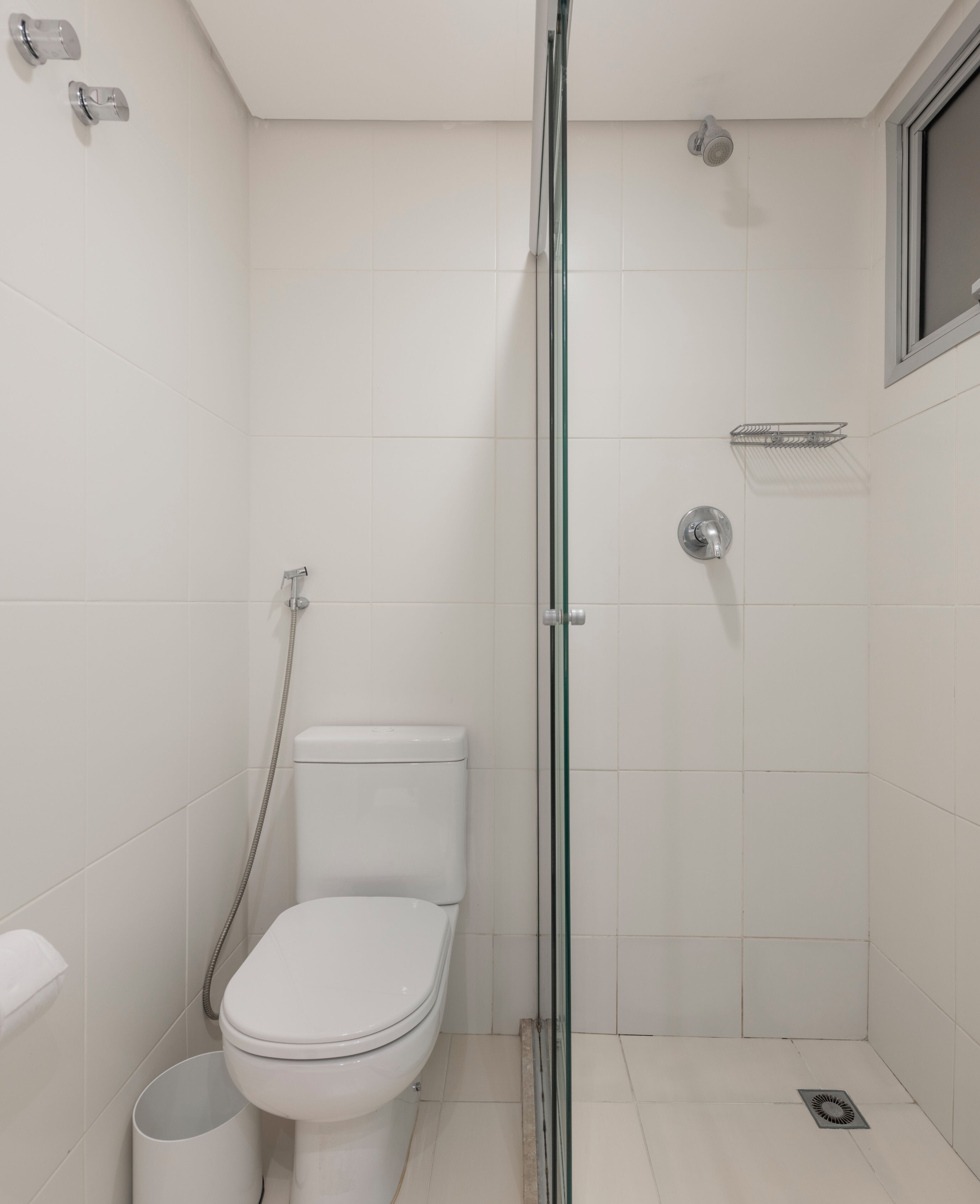 Un bagno moderno e piccolo, con box doccia in vetro, un water e un bidet.