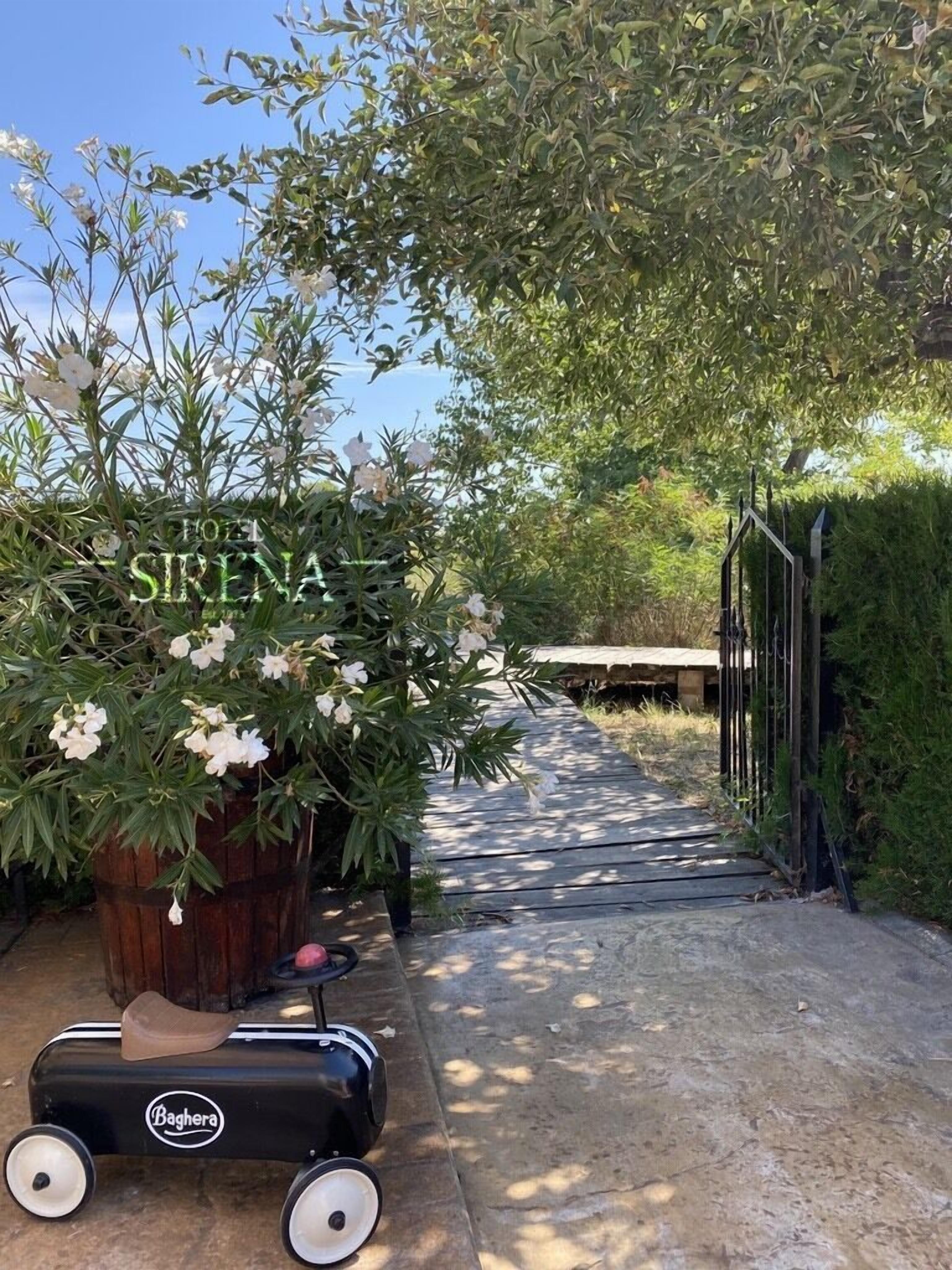 A pathway leading to a hotel entrance with a sign reading "HOTEL SIRENA".