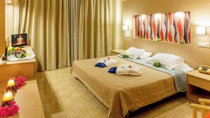 A hotel room with a bed, a desk with a computer and a phone, a TV, and a curtain. - Marianna Palace (Rhodes)