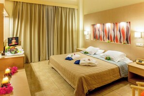 A hotel room with a bed, a desk with a computer and a phone, a TV, and a curtain. - Marianna Palace (Rhodes)