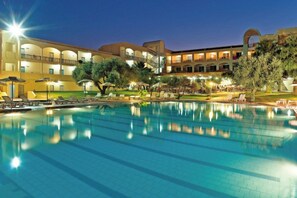 A hotel with a swimming pool, multiple balconies, and outdoor seating areas. - Marianna Palace (Rhodes)