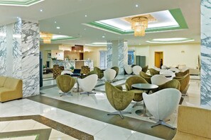 A modern hotel lobby with marble columns, a reception desk, and contemporary seating areas. - Marianna Palace (Rhodes)