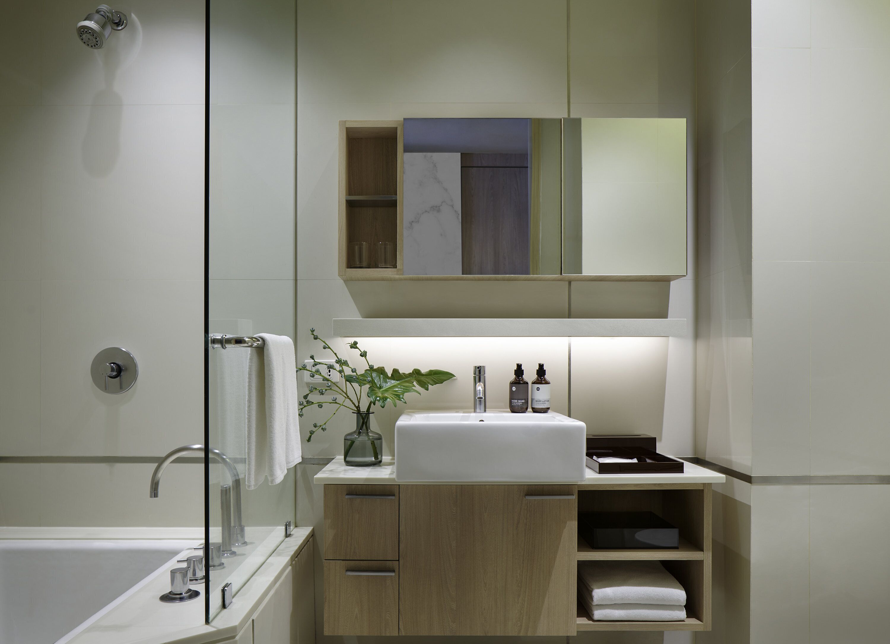 Un baño moderno con bañera, lavamanos y espejo sobre el mostrador.