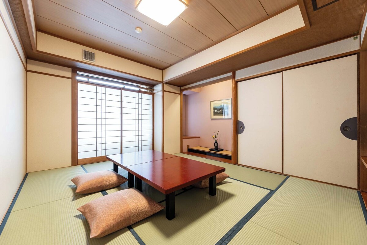 Une pièce de style japonais traditionnel, avec un sol recouvert de tatamis, une basse table en bois et des portes coulissantes.