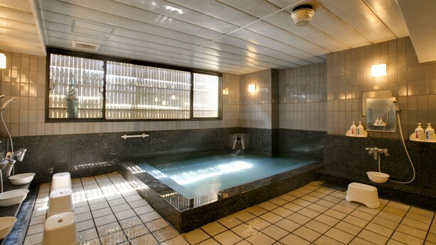 Une salle de bain moderne avec une grande baignoire, des toilettes et un lavabo.
