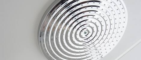 A modern showerhead with a circular design and a separate handheld shower attachment.