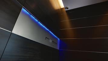 A modern interior with a prominent 'Femm' sign, wooden paneling, and blue LED lighting.