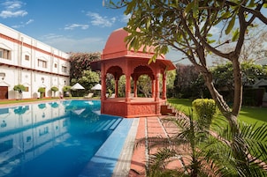 Una piscina al aire libre, sombrillas, sillones reclinables de piscina
