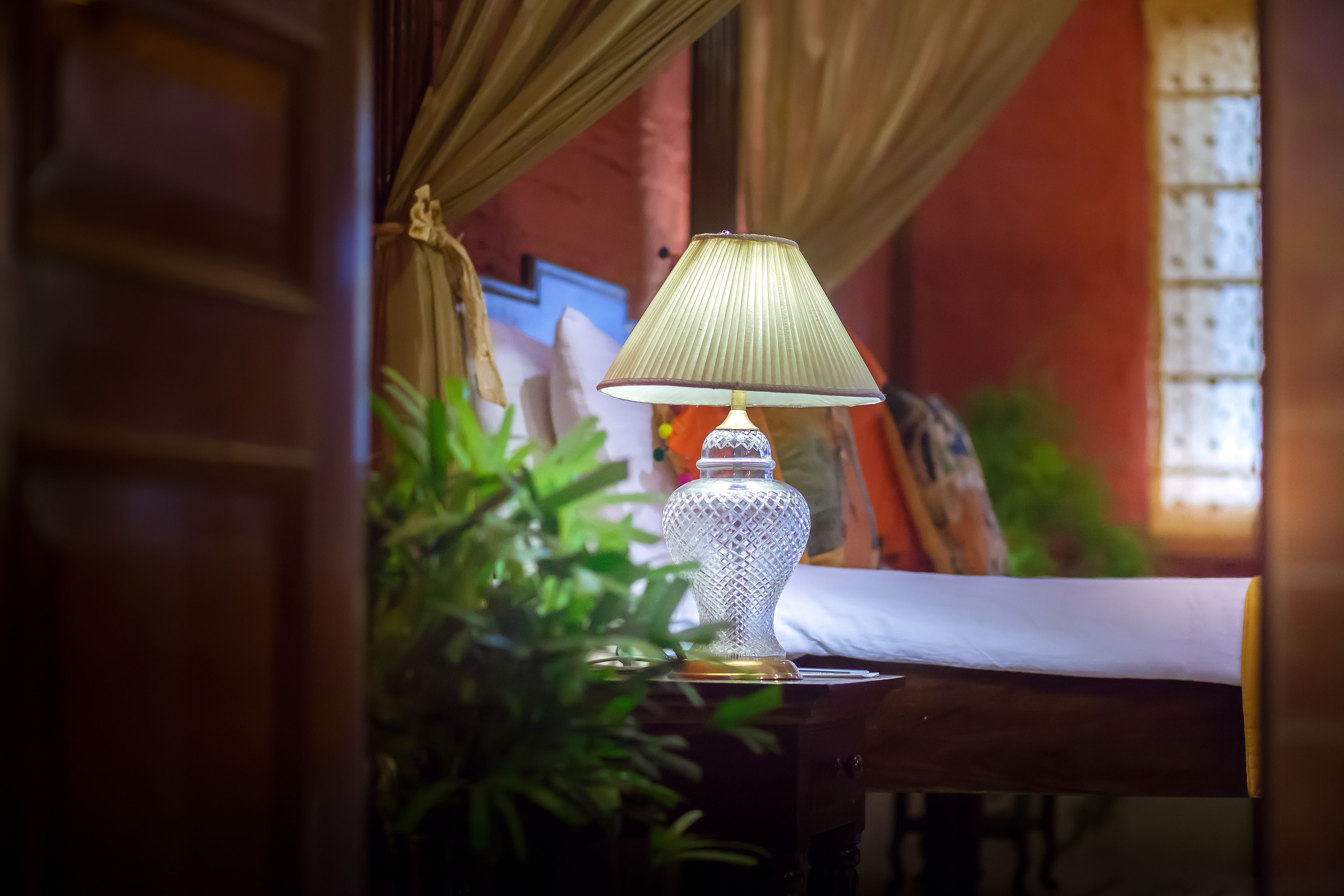 Una lámpara sobre una mesa con una cortina al fondo.
