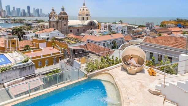 A rooftop pool with a view of a historic cityscape, including a cathedral and a modern skyline. - Movich Hotel Cartagena de Indias (Cartagena)