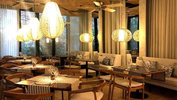 A spacious dining area with wooden furniture and hanging light fixtures.