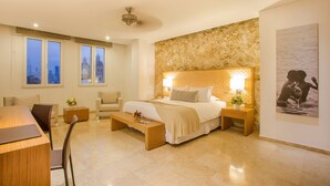 A modern bedroom with a large bed, a desk, and a chair. There are two bedside tables with lamps. - Movich Hotel Cartagena de Indias (Cartagena)