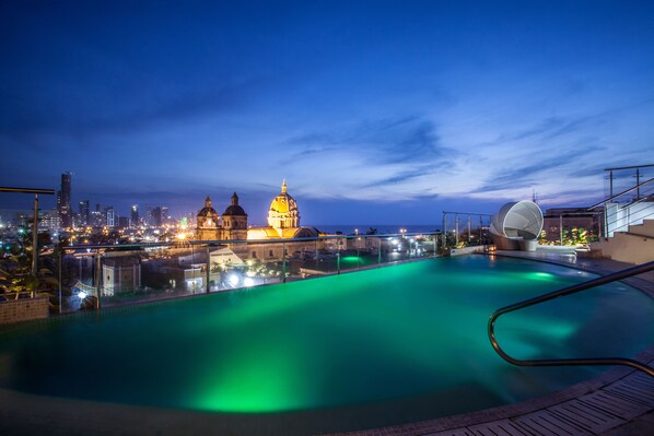 A rooftop pool with a cityscape view, including domed buildings and modern architecture.