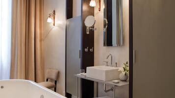 Un baño moderno con una bañera independiente, un tocador con espejo y un perchero para toallas.