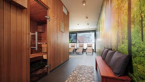 A hallway with a wooden bench, a sauna area, and a wall with a forest mural. - NOVINA HOTEL Tillypark (Nuremberg)
