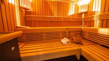 Eine Sauna mit Holzbänken, einem Holzfass und einem Handtuch.