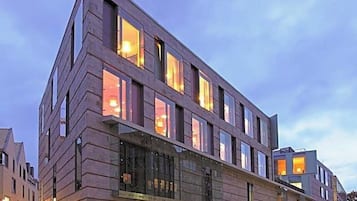 A multi-story hotel with a modern design, featuring large windows and a ground-level entrance.