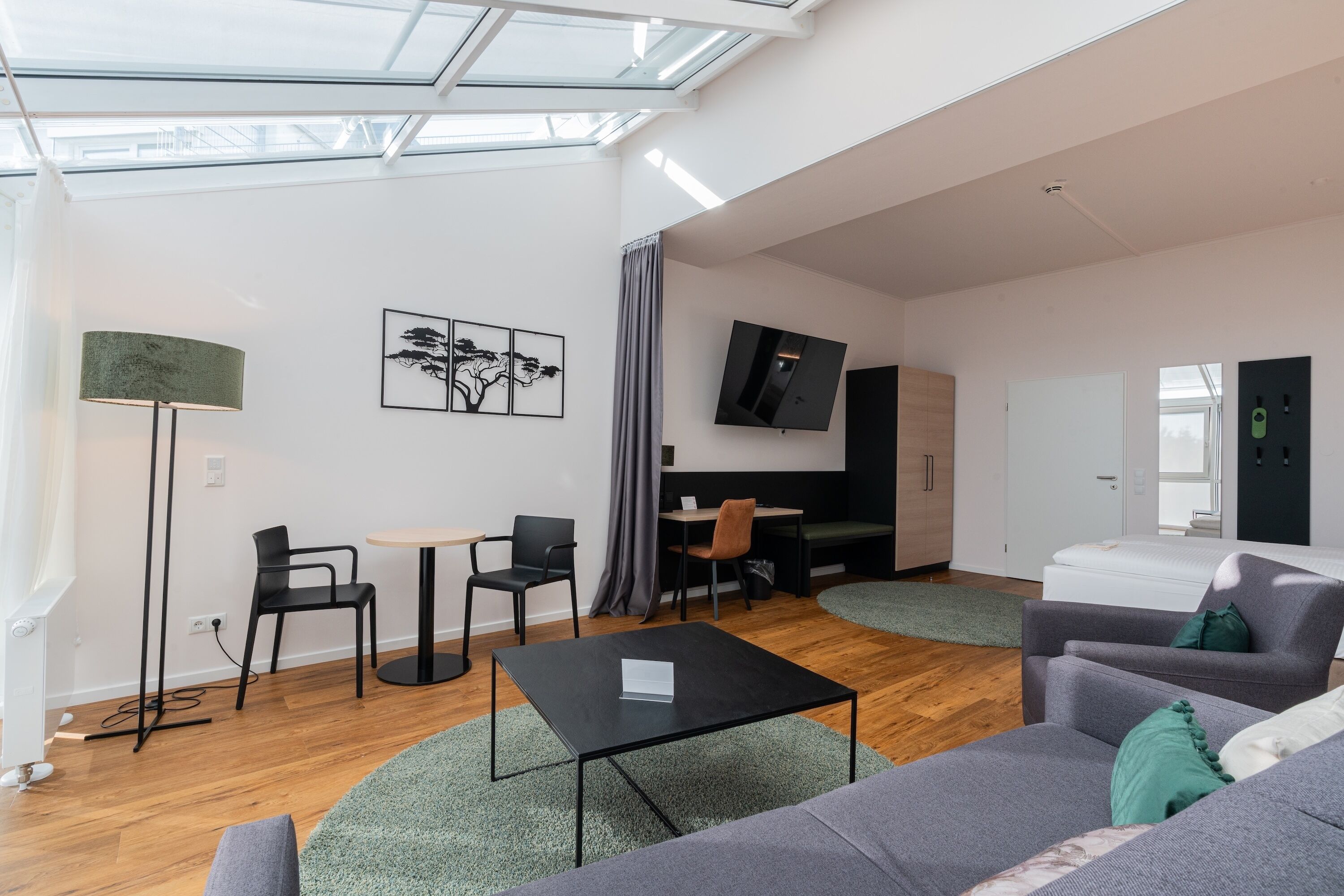 A modern living room with a sofa, coffee table, and a TV mounted on the wall.
