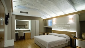 A modern bedroom with a large bed, a desk, and a vanity. - Byzantino Hotel Patras (Patras)