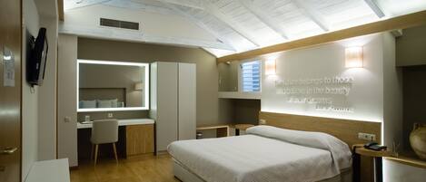 Un dormitorio moderno con una cama grande, un escritorio y un tocador.