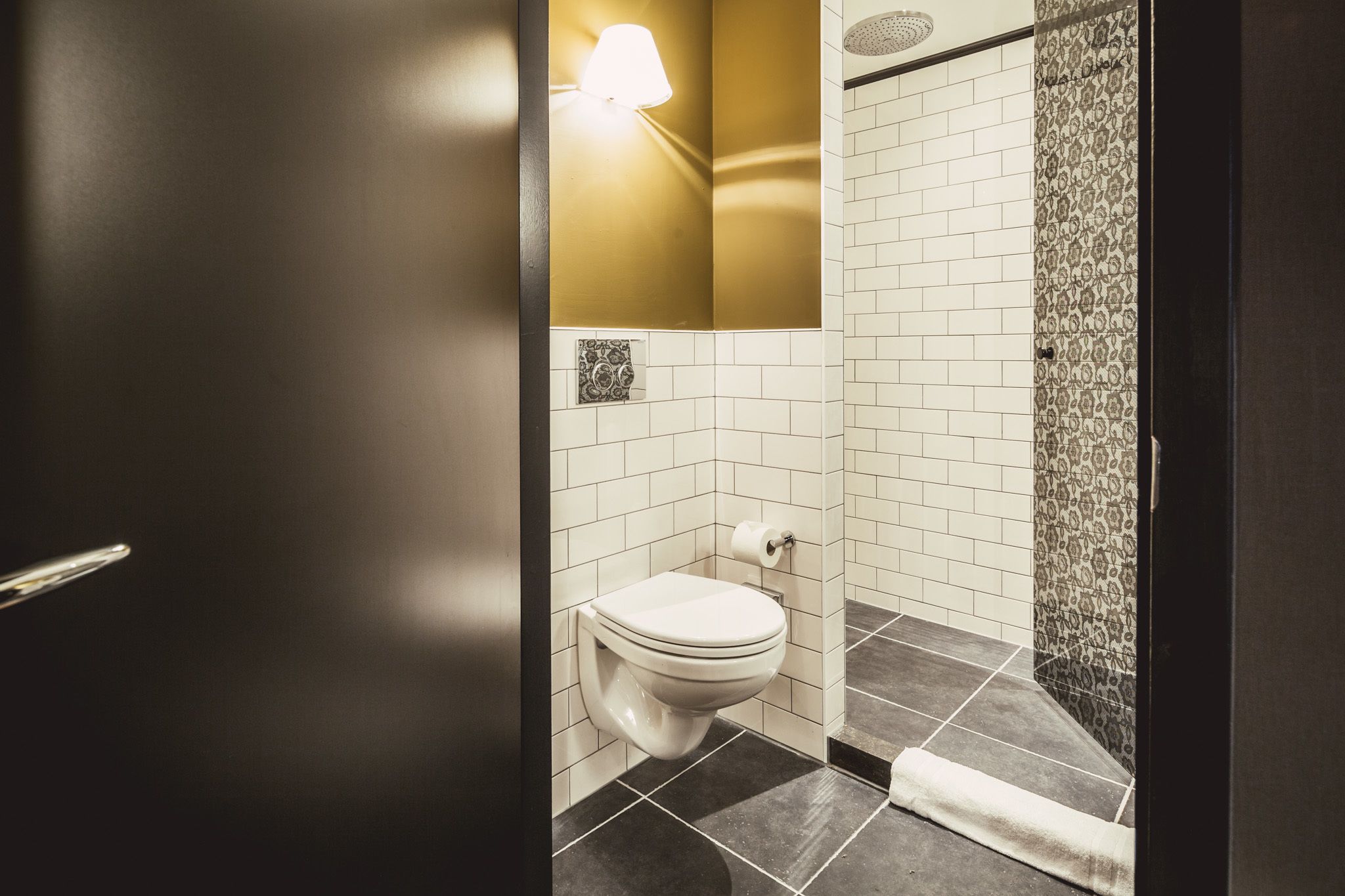 Un bagno con il water, un portasciugamani e una zona doccia.
