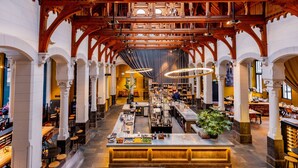 A spacious hotel lobby with a central bar, high wooden beams, and multiple seating areas. - Post-Plaza Hotel & Grand Café (Leeuwarden)