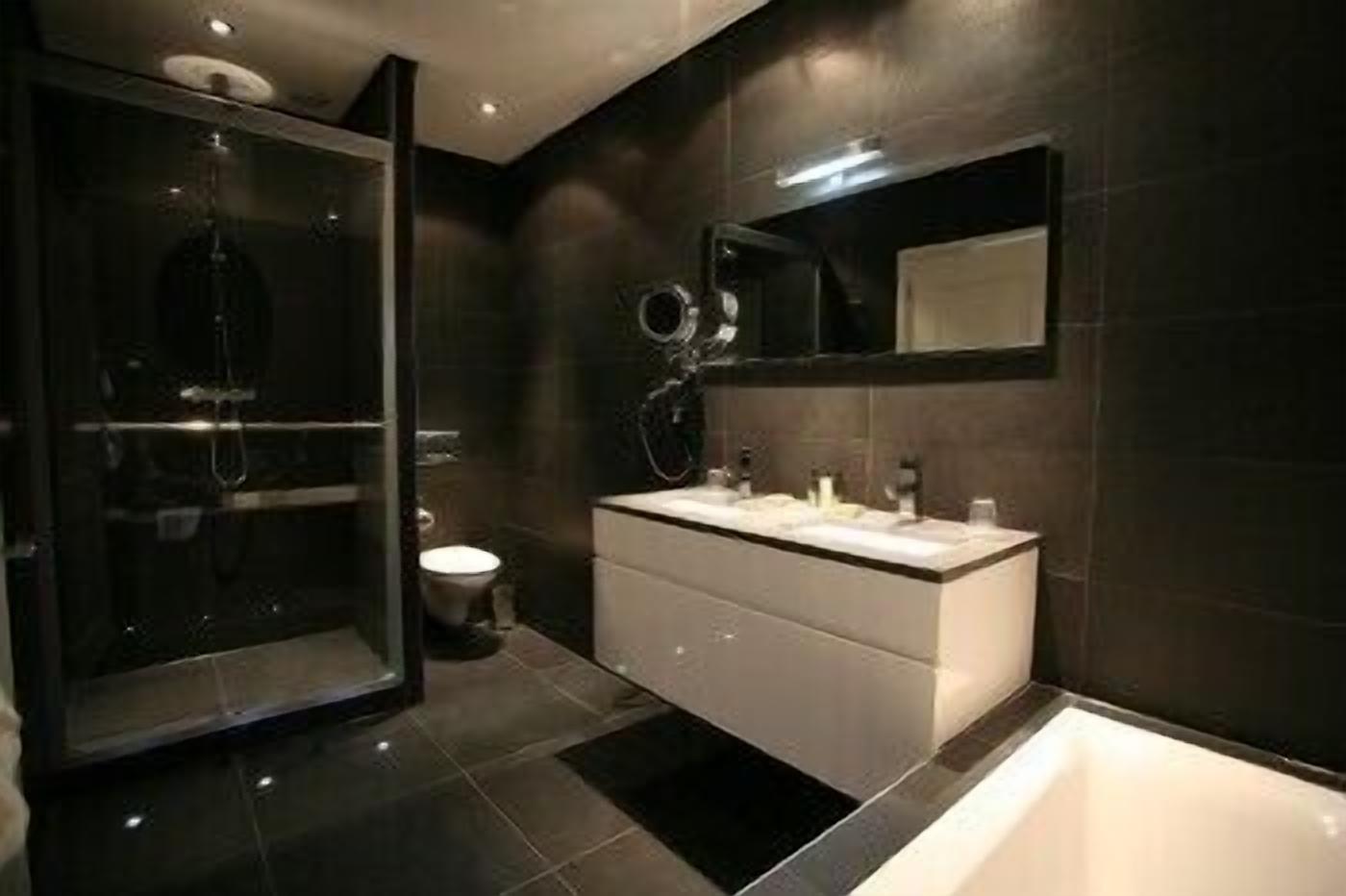 A modern bathroom with a walk-in shower, a large mirror, and a bathtub.