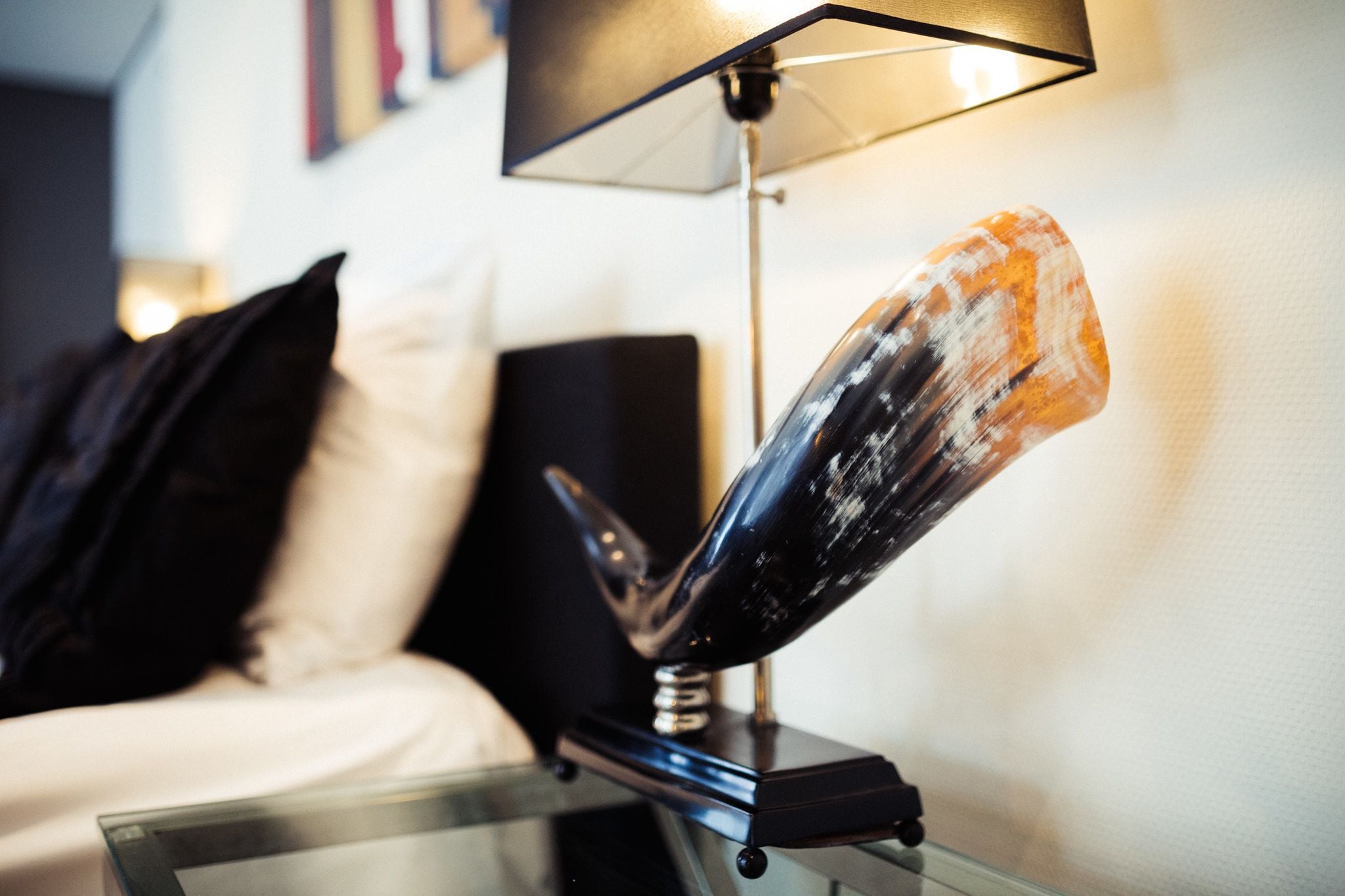 A modern lamp with a unique design on a bedside table in a hotel room.