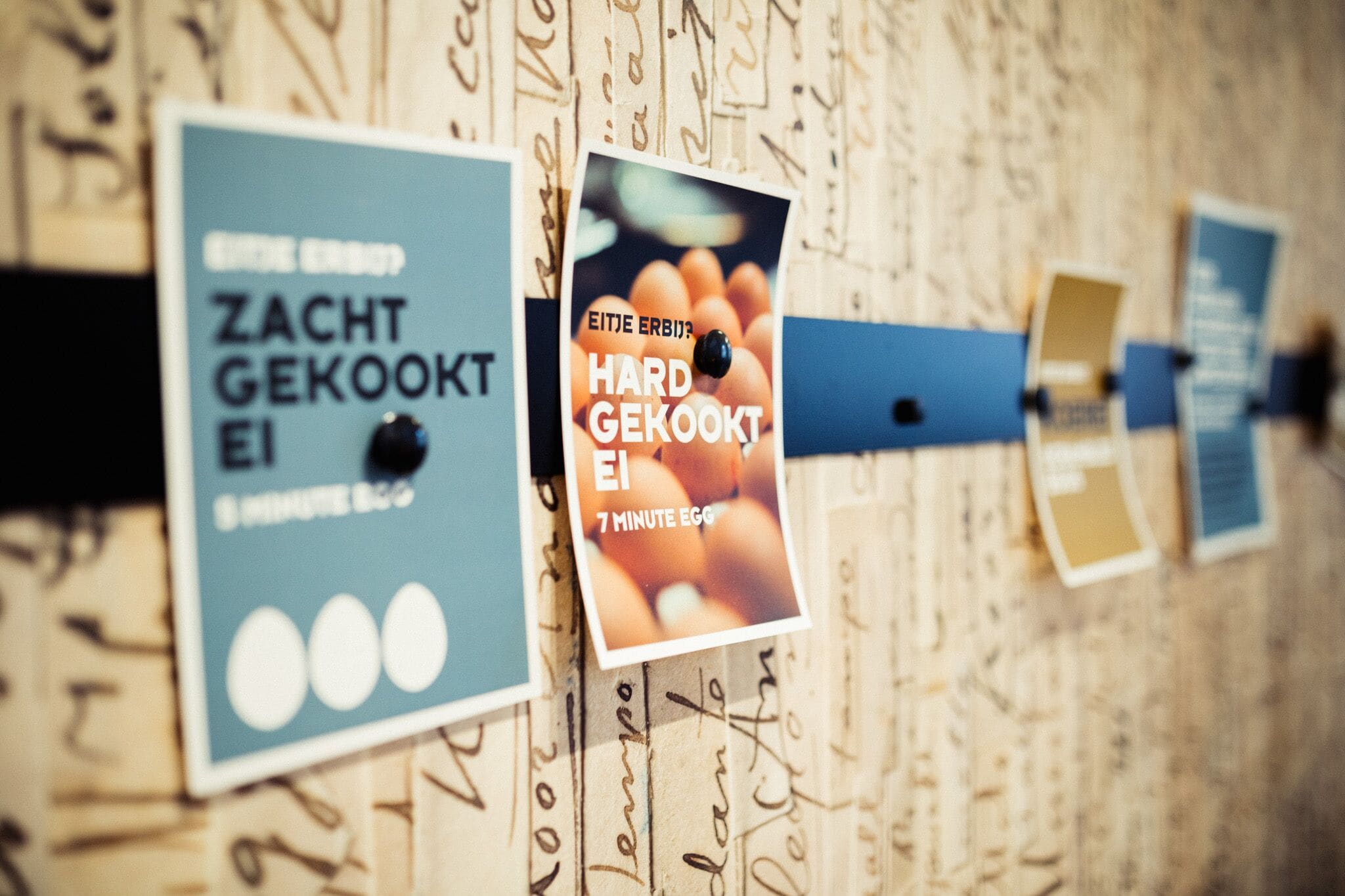 A wall with various signs, including one that says "ZACHT GEKOOKT" and another that says "HARD GEKOOKT."