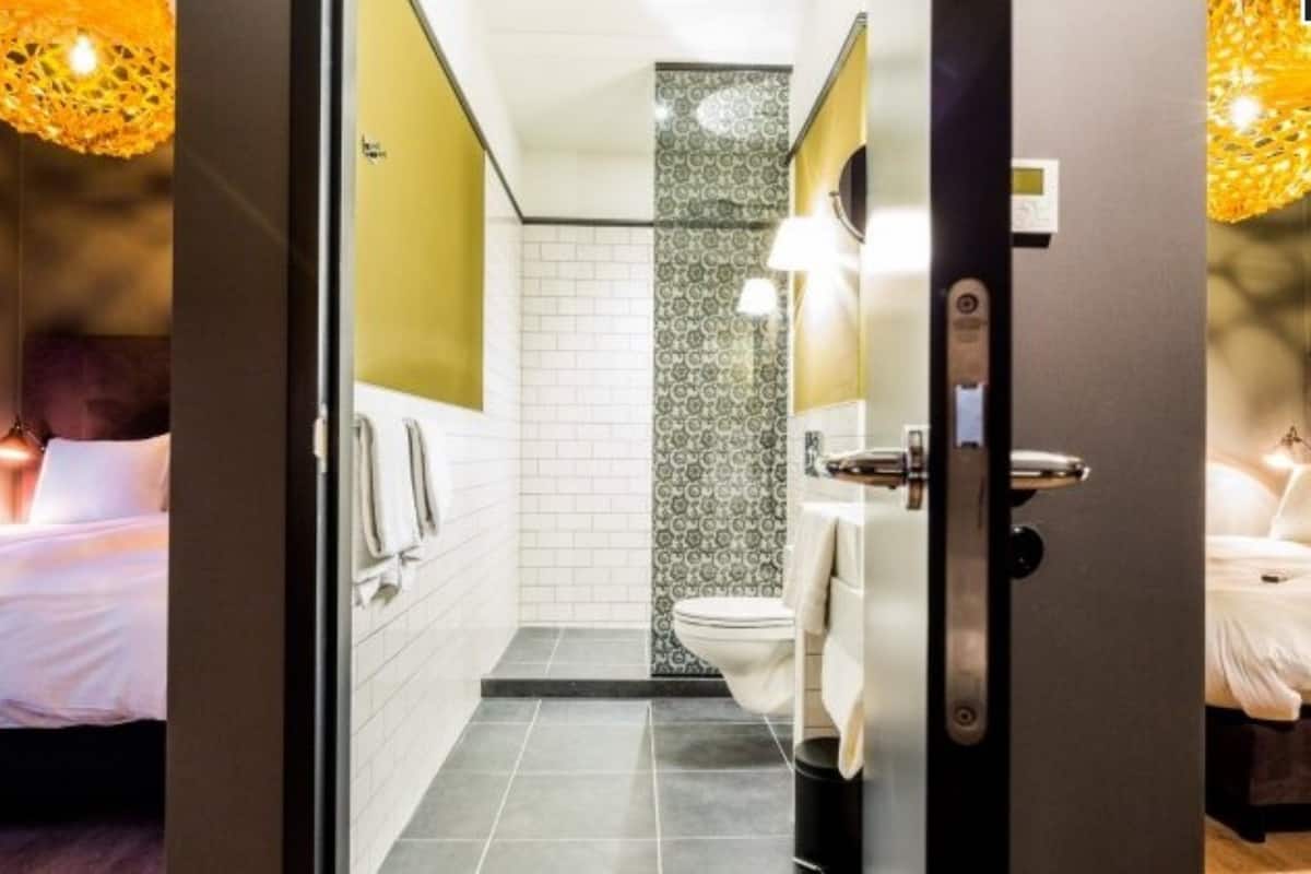 Ein Hotelzimmer mit einem Bett, einem Badezimmer mit Toilette und Waschbecken sowie einer Duschkabine.
