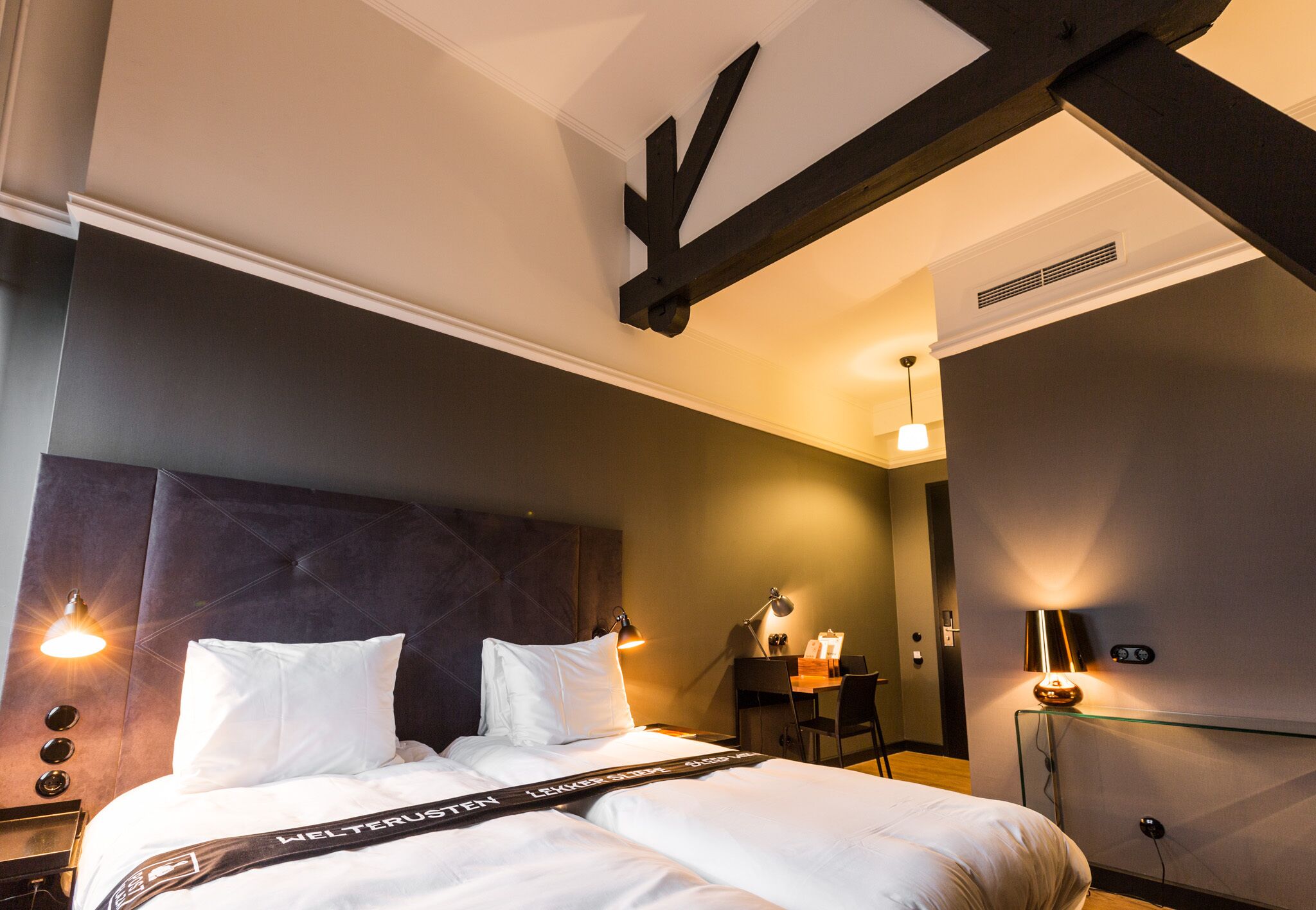 Una habitación de hotel con una cama grande, un escritorio y una silla.