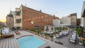Una piscina al aire libre, sillones reclinables de piscina