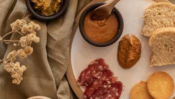 Un plato con diversos alimentos, como pan, galletas y una crema, sobre una superficie cubierta con tela.