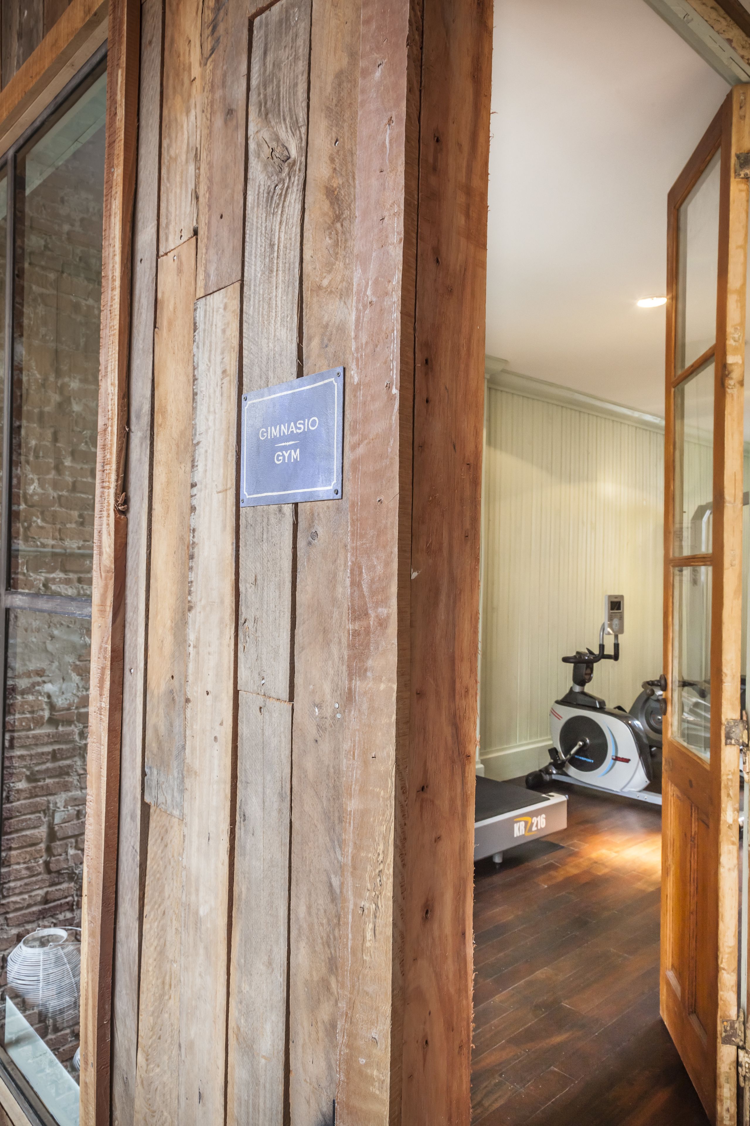 A wooden wall with a sign reading "GIMNASIO GYM".