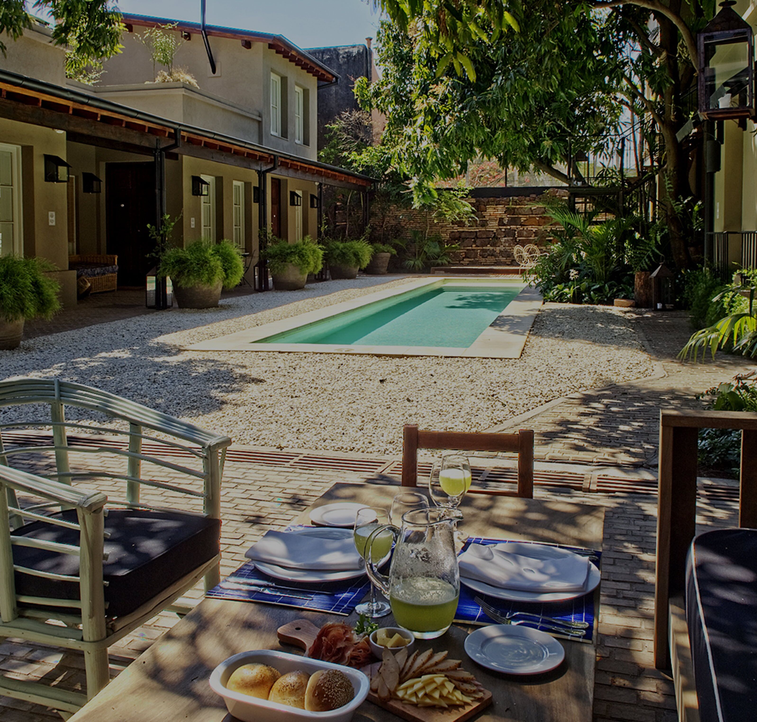 Un espace piscine aménagé avec un coin repas comprenant une table, des chaises et une variété de plats.