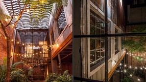Een meerlaags atrium met een trap, lichtslingers en potplanten.