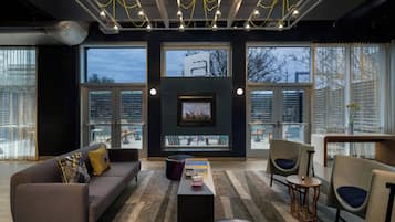 A modern living room with a sofa, chairs, a coffee table, and a fireplace.