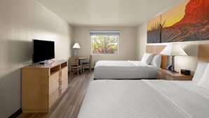 A hotel room with two beds, a desk with a chair, a television, and a window with a view of trees. - Days Inn by Wyndham Chino Valley (Chino Valley)